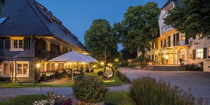 Golfurlaub - Parkplatz - Schwarzwald - Abendstimmung im Parkhotel Adler mit Restaurantterrasse vor dem historischen Schwarzwaldhaus, das Haupthaus rechts wurde 1890 gebaut. - Parkhotel Adler 