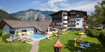 Golfurlaub - Pools: Außenpool beheizt - Berwang - Hotel Karlwirt Aussenansicht mit Pool und Parkanlage - Hotel Karlwirt - Alpine Wellness am Achensee