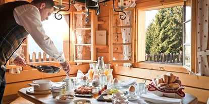 Golfurlaub - Abendmenü: à la carte - Murau (Murau) - Der Hüttenwirt bereitet das Frühstück in der Hütte vor.  - Almdorf Seinerzeit
