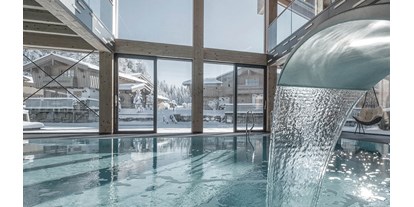 Golfurlaub - Hotel-Schwerpunkt: Golf & Wellness - Oberösterreich - INNs HOLZ Ausblick vom Indoorpool auf das Chaletdorf im Winter - INNs HOLZ Chaletdorf