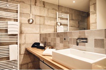 Golfhotel: Das modern und hochwertig gestaltete Bad lädt zum Entspannen unter einer großzügigen Regendusche ein.

 - Nordenholzer Hofhotel