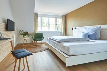 Golfhotel: Jedes der Komfortdoppelzimmer (26-35qm) bietet mit Kingsize-Bett, Sitzecke und Blick ins Grüne eine kleine Oase der Erholung. Dänische Fenster geben den Räumen ein schönes helles und luftiges Raumgefühl.  - Nordenholzer Hofhotel