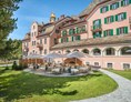 Golfhotel: Grosszügiger Hotelpark mit mächtigen Bäumen und einer Sonnenterrasse - Parkhotel Margna
