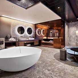 Golfhotel: Badezimmer der Luxury-Suite mit eigener Sauna, freistehende DUO-Badewanne mit Regensystem, 
Wärmebank und Relax-Bereich - 5-Sterne Wellness- & Sporthotel Jagdhof