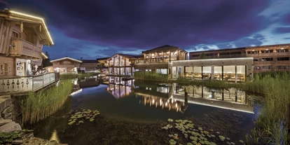 Golfurlaub - Sauna - INNs HOLZ Chaletdorf samt Blick auf den Wellnessbreich mit Indoorpool bei Nacht - INNs HOLZ Chaletdorf