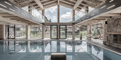 Golfurlaub - Sauna - INNs HOLZ Chaletdorf Indoorpool mit Kamin und Blick auf den INNs HOLZ See und Chalets - INNs HOLZ Chaletdorf