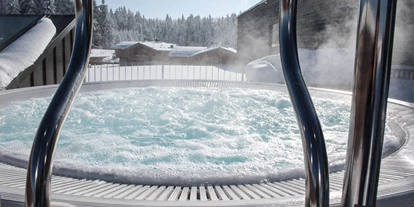 Golfurlaub - Sauna - INNs HOLZ Chaletdorf Wellnessbereich im angrenzenden INNs HOLZ Natur- & Vitalhotel****s Outdoorwhirlpool im Winter - INNs HOLZ Chaletdorf